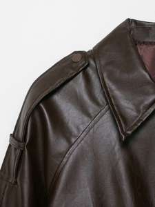 Close-up of dark brown faux leather jacket collar with detailed epaulets and metal snap buttons