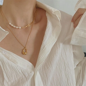 Elegant double layered pearl and gold chain necklace featuring an irregular water drop pendant