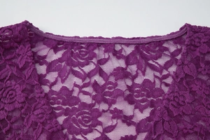 Détail de la dentelle violette avec des motifs de roses et une texture transparente