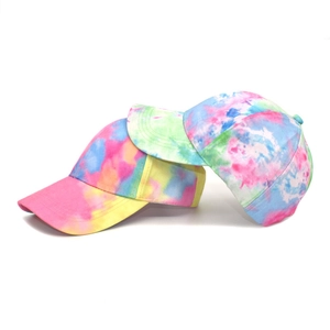 Close-up of vibrant tie-dye baseball caps with colorful pink, blue and yellow patterns
