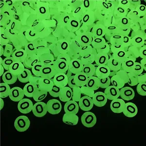 Macro shot of luminous flat round acrylic beads glowing in green with black letter O print