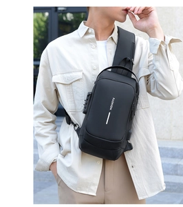Detail of black tactical sling bag featuring security lock and integrated USB charging port