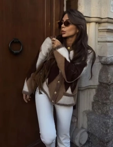 Detail of vintage knit cardigan with argyle pattern, V-neck and gold buttons on the street