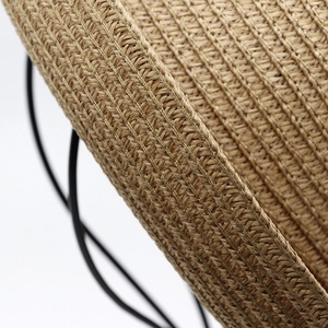 Close-up of the woven texture on a natural straw sun hat with detailed fiber structure