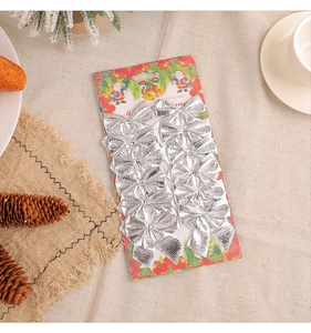 Detail of 12 silver Christmas bow ornaments on themed card with festive pine decorations