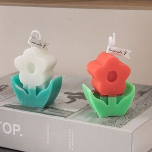 Minimalist flower-shaped scented candles in tulip design on a decorative book
