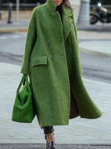 Detail of green long wool coat featuring wide lapels and double-breasted buttons