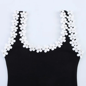 Detail of the black dress neckline with white floral lace trim and crystal rhinestone accents