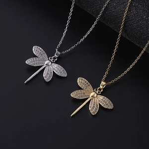 Macro shot of gold and silver dragonfly pendants with micro-pave cubic zirconia crystals