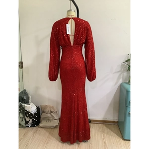 Dettaglio dell'abito rosso con paillettes con maniche a sbuffo e apertura sulla schiena