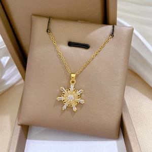 Close-up of a gold snowflake pendant necklace featuring sparkling zircon stones