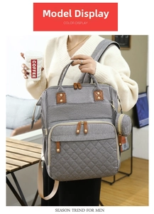 Gray large capacity diaper backpack with quilted details and matching small round pouch