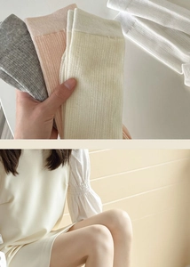 Detailed texture of ribbed knit slouch socks in soft grey, pink, cream and white colors