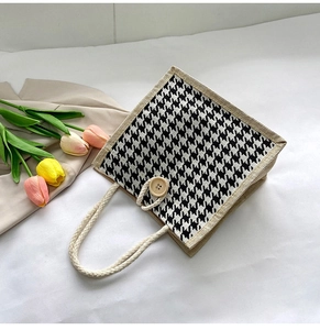 Detail of canvas tote bag with houndstooth pattern, hemp handles and wooden button