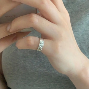 Minimalist S925 sterling silver ring with hollow heart pattern shown on hand