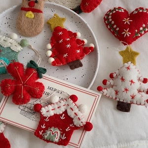 Close-up of handmade wool felt Christmas ornaments with embroidery and festive details