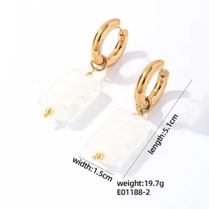 Detail showing white marble stone earrings with gold hoops and dimensions 5.1cm by 1.5cm