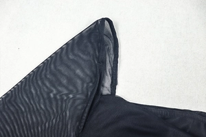 Gros plan sur la couture d'épaule et la texture du tissu en maille d'une robe noire