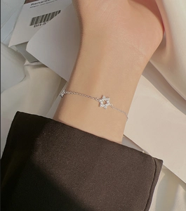 Detail of a silver hexagram star bracelet with sparkling zircon stones on a model's wrist