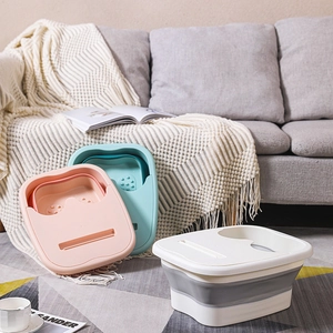 Collapsible foot spa tub in pink, cyan and white colors on a home rug background