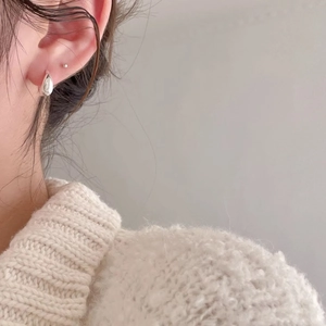 Elegant polished sterling silver water drop earrings shown on a model with knitwear