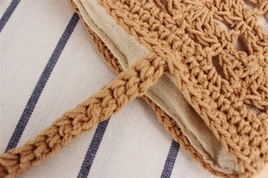 Close-up of brown hollow cotton rope woven bag with light-colored lining and sturdy handle