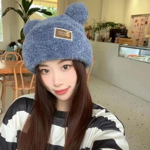 Detail of blue plush knit hat featuring cute bear ears and Somieus Fashion patch labels
