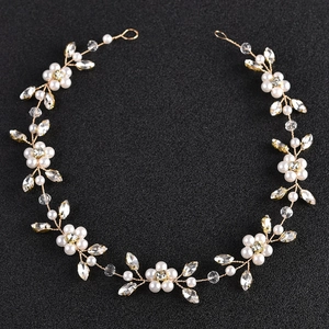 Detailed top view of a gold bridal hair chain with white pearls and crystals