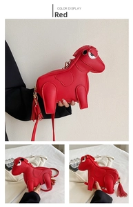 Detail of red horse-shaped crossbody bag with lychee grain texture and fringe charm