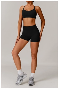 Detailed full-body shot of women's seamless black yoga set with sports bra and high-waisted shorts