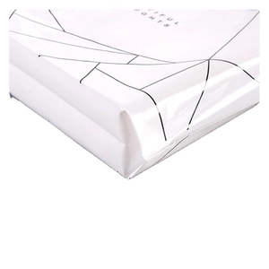 Detailed close-up of white PE plastic shopping bag with black geometric patterns