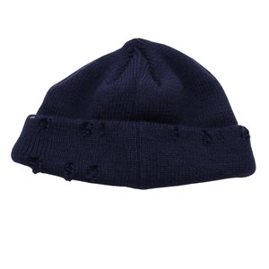 Dettaglio del berretto in maglia blu scuro con strappi in stile vintage e bordo arrotolato