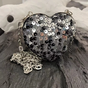 Detail of silver chain strap on black and silver sequined heart evening clutch bag