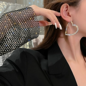 Elegant oversized heart hoop earrings with sparkling rhinestones worn by a model