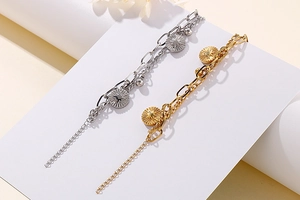 Detail view of double-layer titanium steel bracelet with sunburst coin charms in gold and silver