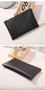 Macro view of black lychee grain texture and silver metal zipper on flat PU storage bag