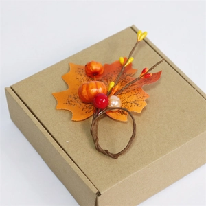 Autumn harvest napkin ring with maple leaf, mini pumpkin and red berries for Thanksgiving