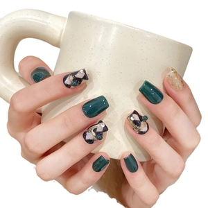Emerald green geometric press-on nails with gold accents and pearl rhinestones