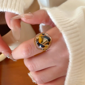 Detail of amber leopard resin ring with gold accents and a glossy finish