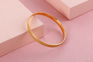Close-up of golden matte titanium steel bracelet with textured geometric display