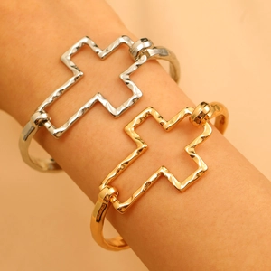 Detailed view of hammered metal cross bangles in gold and silver finish