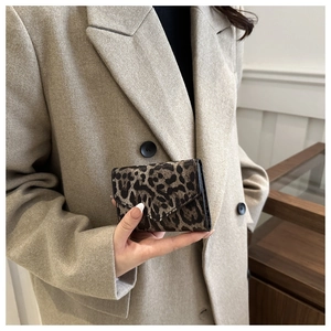 Dettaglio mini pochette leopardata a busta tenuta da modella in blazer beige