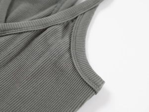 Close-up detail of grey ribbed knit fabric texture and high-quality stitching on vest