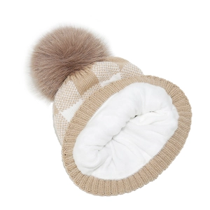 Detail of warm winter knit beanie with soft fleece lining and fluffy faux fur pompom
