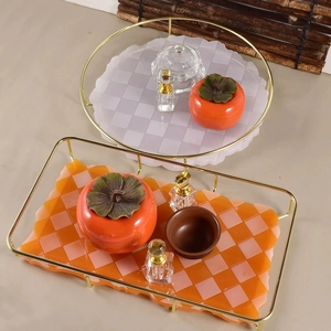 Detail of checkered resin trays with gold metal frames for jewelry and tea sets