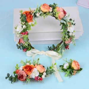 Flat lay of peach rose flower crown, hair comb, and corsage on a blue backdrop