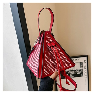 Close-up of a red triangular handbag with silver rhinestone studs and drawstring closure