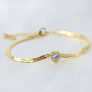 Macro detail of 14K gold stainless steel snake chain with a sparkling heart-shaped zircon