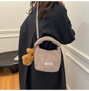 Détail du sac seau beige en laine d'agneau avec charm ours en peluche et bandoulière amovible