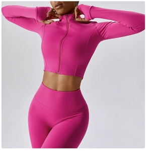 Vue détaillée de la veste de yoga rose avec passe-pouces et fermeture éclair frontale